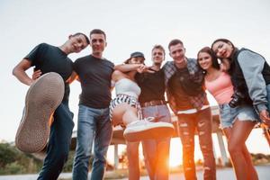 s'embrassant. groupe de jeunes amis joyeux s'amusant ensemble. faire la fête en plein air photo