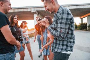 parler et rire. groupe de jeunes amis joyeux s'amusant ensemble. faire la fête en plein air photo