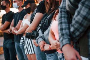 photographe avec appareil photo. groupe de jeunes protestataires qui se tiennent ensemble. militant pour les droits de l'homme ou contre le gouvernement photo