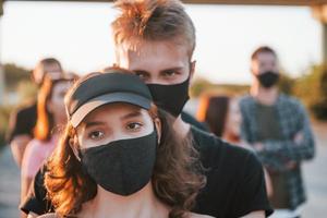 couple s'embrassant. groupe de jeunes protestataires qui se tiennent ensemble. militant pour les droits de l'homme ou contre le gouvernement photo