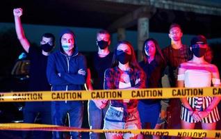 ligne de police et fumée. groupe de jeunes protestataires qui se tiennent ensemble. militant pour les droits de l'homme ou contre le gouvernement photo