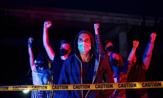 dans des masques de protection. groupe de jeunes protestataires qui se tiennent ensemble. militant pour les droits de l'homme ou contre le gouvernement photo