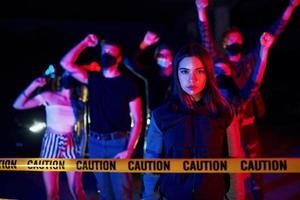 belle femme près de la frontière de la police. groupe de jeunes protestataires qui se tiennent ensemble. militant pour les droits de l'homme ou contre le gouvernement photo