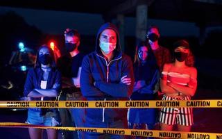 éclairage de police rouge et bleu. groupe de jeunes protestataires qui se tiennent ensemble. militant pour les droits de l'homme ou contre le gouvernement photo