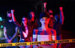 femme calme debout devant la foule. groupe de jeunes protestataires qui se tiennent ensemble. militant pour les droits de l'homme ou contre le gouvernement photo