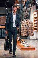 Jour de shopping. jeune homme dans un magasin moderne avec de nouveaux vêtements. vêtements élégants et chers pour hommes photo