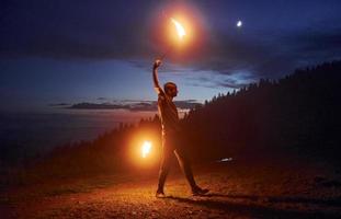 spectacle de feu par l'homme dans les montagnes des carpates de nuit. beau paysage photo