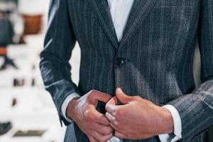 vue rapprochée. jeune homme dans un magasin moderne avec de nouveaux vêtements. vêtements élégants et chers pour hommes photo