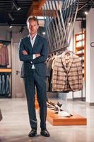 Jour de shopping. jeune homme dans un magasin moderne avec de nouveaux vêtements. vêtements élégants et chers pour hommes photo