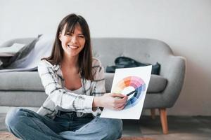 femme positive sourit. la jeune travailleuse indépendante est à l'intérieur de la maison pendant la journée photo