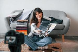 la caméra est au sol. la jeune travailleuse indépendante est à l'intérieur de la maison pendant la journée photo