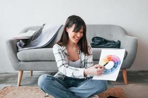 femme positive sourit. la jeune travailleuse indépendante est à l'intérieur de la maison pendant la journée photo