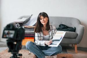 la caméra est au sol. la jeune travailleuse indépendante est à l'intérieur de la maison pendant la journée photo