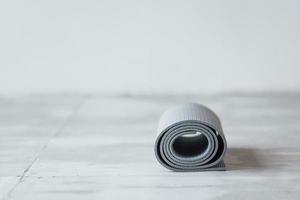 tapis de yoga gris allongé sur le parquet du studio photo