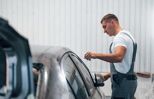 Réparateur automobile caucasien en uniforme travaille dans un garage photo