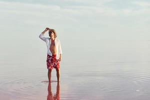 homme au chapeau et vêtements décontractés se promène sur le lac de l'île de jarilgach, ukraine photo