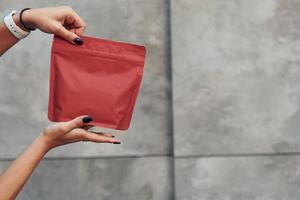 vue rapprochée des mains de la femme qui contient un paquet rouge de nouveau café photo