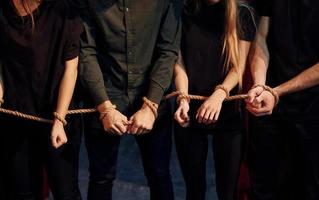 avec une corde dans les mains. groupe d'acteurs vêtus de vêtements de couleur sombre en répétition au théâtre photo