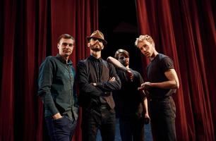 posant pour un appareil photo. groupe d'acteurs vêtus de vêtements de couleur sombre en répétition au théâtre photo