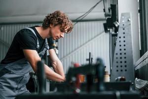 homme adulte en uniforme de couleur grise travaille dans le salon de l'automobile photo