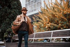 jeune mannequin en vêtements à la mode est à l'extérieur de la ville pendant la journée photo