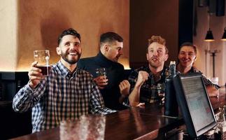 des gens expressifs qui regardent le football. groupe de personnes ensemble à l'intérieur dans le pub s'amuser le week-end photo