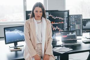 pose pour la caméra. la jeune femme est à l'intérieur du bureau. beaucoup d'affichages photo