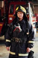 femme pompier en uniforme de protection debout près du camion photo