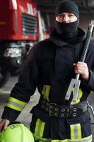pompier masculin en uniforme de protection debout près du camion photo