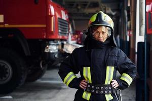 femme pompier en uniforme de protection debout près du camion photo