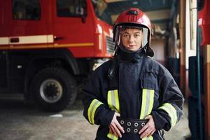 femme pompier en uniforme de protection debout près du camion photo