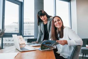 deux femmes en vêtements formels sont à l'intérieur dans le bureau moderne travaillent ensemble photo