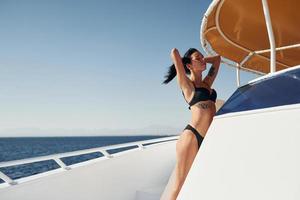 jeune brune en bikini est sur le yacht blanc sur la mer. conception de vacances photo