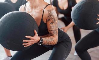 occupé en faisant des exercices. un groupe de jeunes sportifs a une journée de crossfit à l'intérieur dans une salle de sport photo