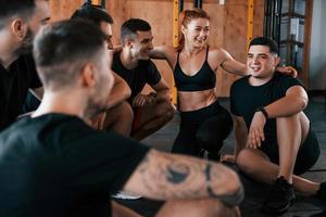 faire une pause. un groupe de jeunes sportifs a une journée de crossfit à l'intérieur dans une salle de sport photo