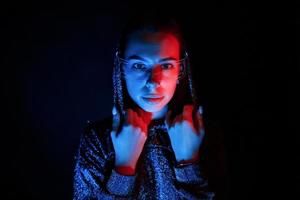 portrait de jeune fille qui porte des lunettes dans un éclairage au néon bleu photo