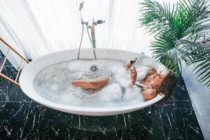 vue de dessus. belle jeune femme a du temps libre à la maison dans le bain photo