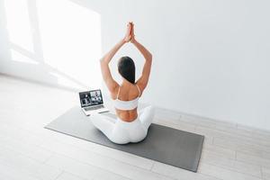 avec ordinateur portable. jeune femme caucasienne avec une forme de corps mince est à l'intérieur pendant la journée photo