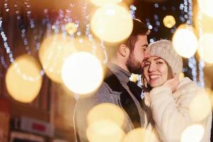 proximité des gens. heureux jeune couple célébrant le nouvel an à l'extérieur dans la rue photo