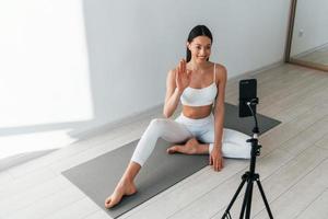 le téléphone enregistre une vidéo. jeune femme caucasienne avec une forme de corps mince est à l'intérieur pendant la journée photo