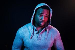 éclairage néon futuriste. jeune homme afro-américain dans le studio photo