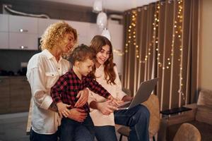 passer le week-end ensemble. une famille heureuse de mère, fille et fils est dans la cuisine le soir photo