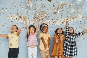 ballons et confettis. les enfants célébrant la fête d'anniversaire à l'intérieur s'amusent ensemble photo