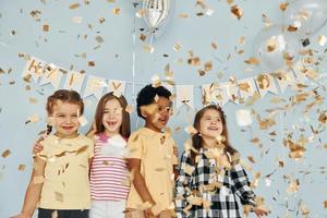 les enfants célébrant la fête d'anniversaire à l'intérieur s'amusent ensemble photo