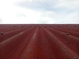 gros plan de couverture de toit rouge. toit de tuiles avec fond de ciel photo