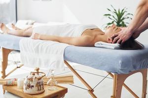 équipement spécial. jeune femme est allongée quand un homme fait un massage de son corps au spa photo