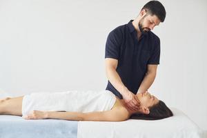 massage crânien. une jeune femme est allongée quand un homme lui fait une procédure au spa photo