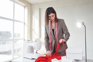 couturière travaillant au bureau. jeune femme en vêtements formels est à l'intérieur. conception du style photo