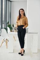 femme en vêtements formels est à l'intérieur dans le bureau moderne pendant la journée photo