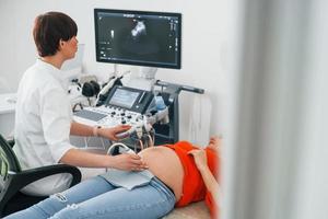 diagnostic échographique. la femme enceinte est à la clinique dans le cabinet et fait un bilan de santé photo